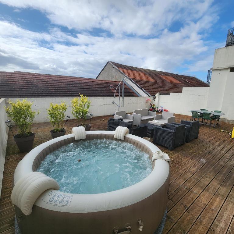 - un bain à remous sur une terrasse avec une table et des chaises dans l'établissement Magnifique logement spa, à Pau