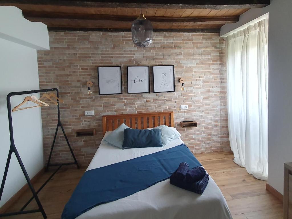 a bedroom with a bed and a brick wall at Apartamentos Cama del Rey 2 habitaciones in Santander