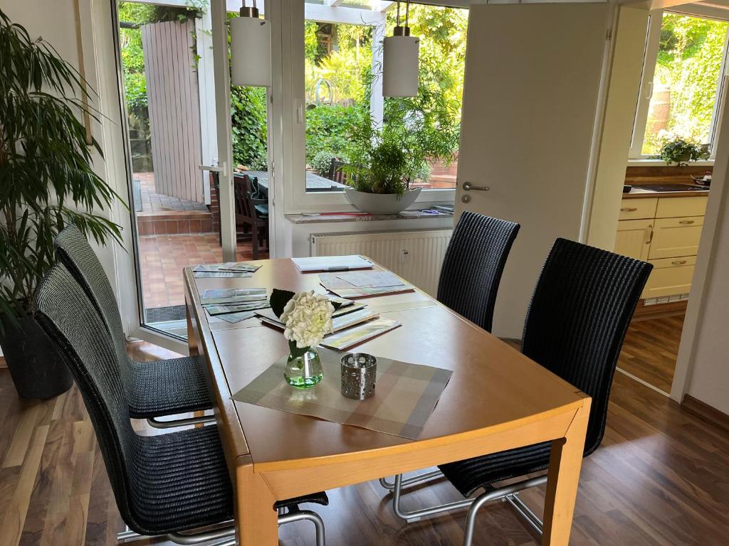 mesa de comedor con sillas negras y mesa en Ferienwohnung "An der alten Mühle" 2 Schlafzimmer, Südbalkon, Gartenterrasse & Wallbox, 100 qm, en Bad Bentheim