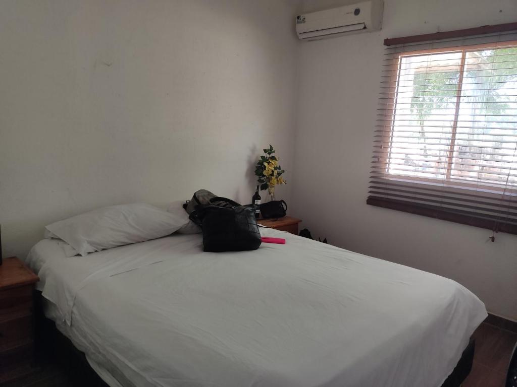 um quarto com uma cama branca com uma mochila em Finca Mar de Leva em Santa Marta
