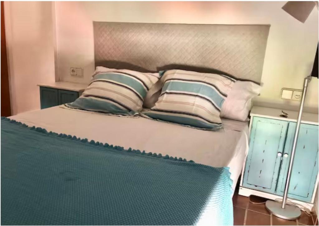 a bedroom with a large bed with pillows at Pals Playa 1era linea de mar, villa de golf in Begur