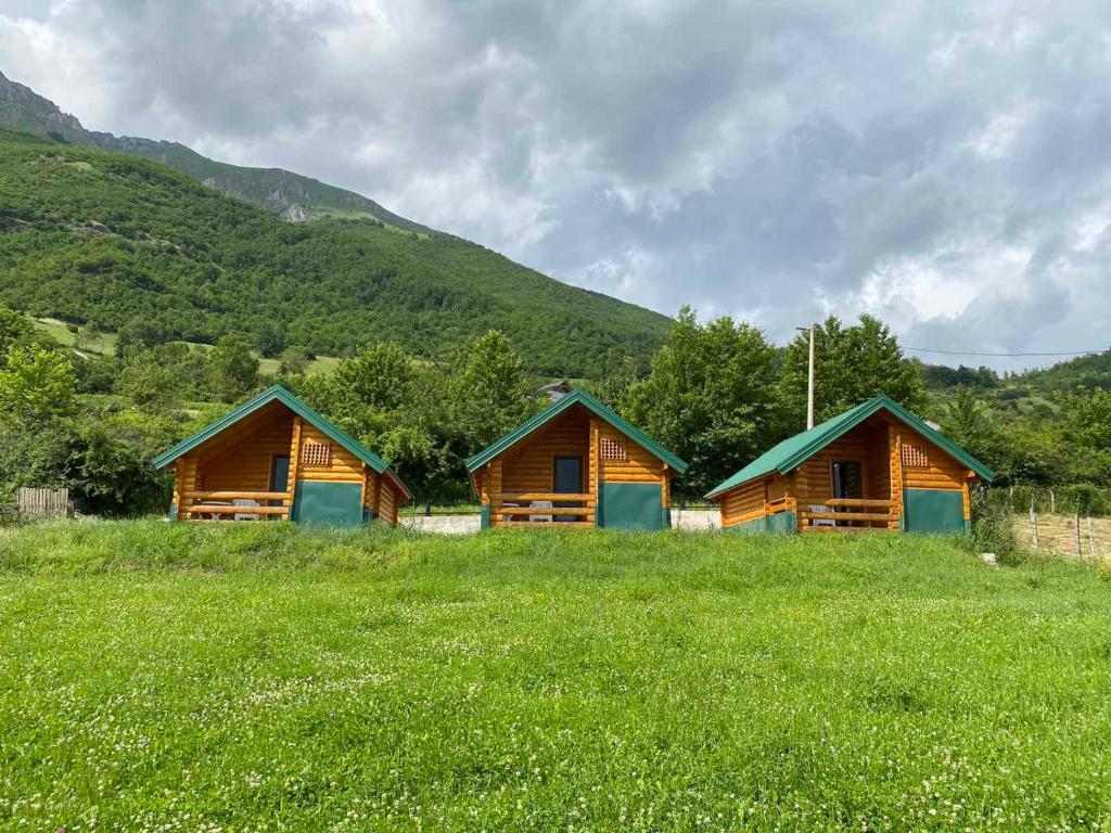 a group of wooden cabins in a field of grass at Gusinje View in Gusinje