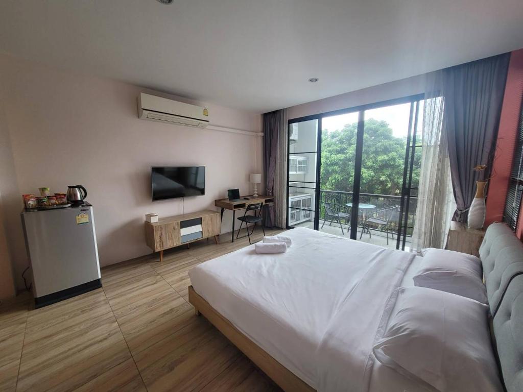 1 dormitorio con 1 cama grande y balcón en THAI HOTEL CHIANGMAI, en Chiang Mai
