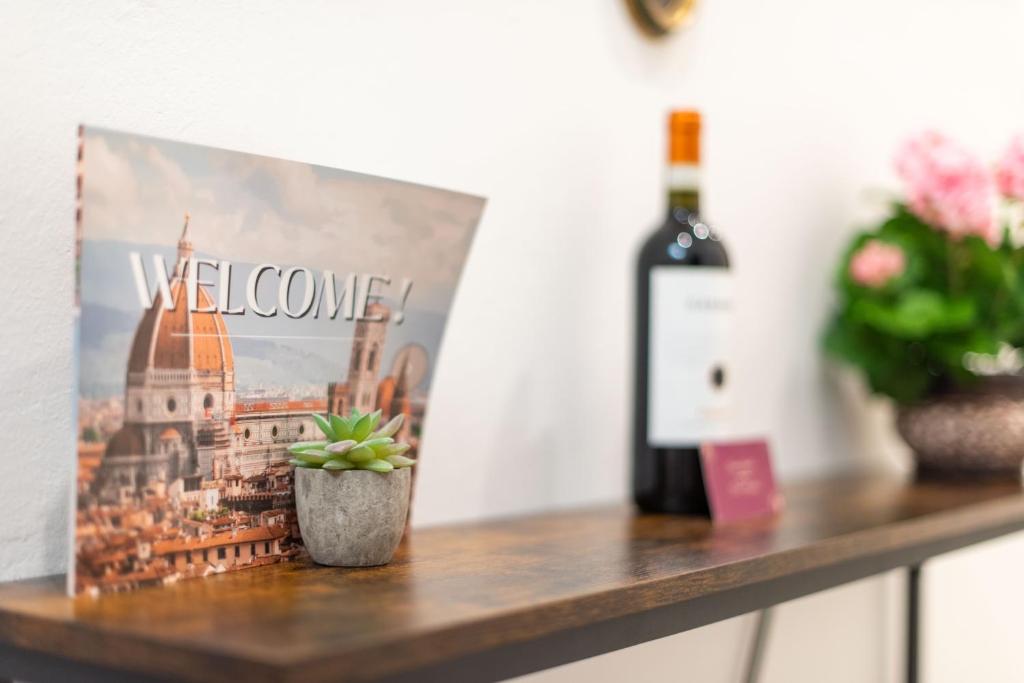 eine Flasche Wein und eine Pflanze auf dem Tisch in der Unterkunft Luxury Home Il Giglio in Florenz