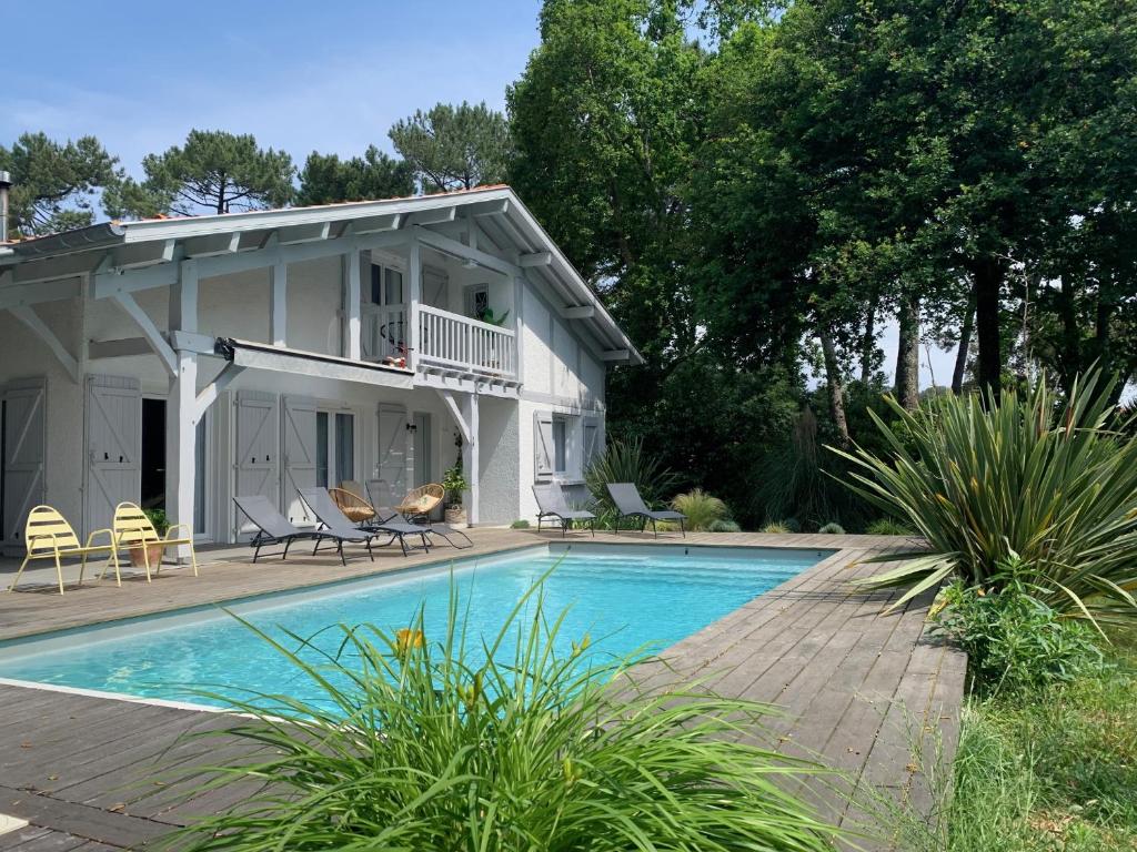 een huis met een zwembad ervoor bij Villa "OSTAU OCÉANE" in Capbreton