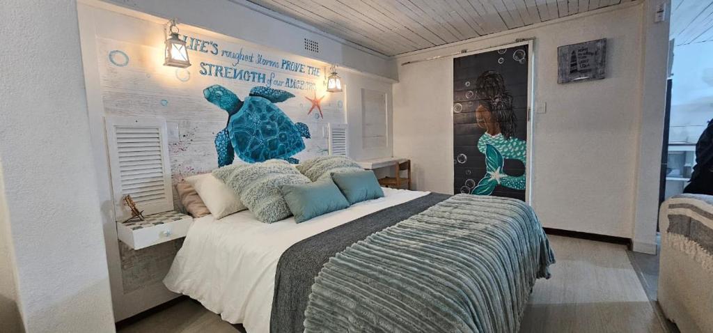 a bedroom with a large bed with a poster on the wall at Cozy Guest in Graskop