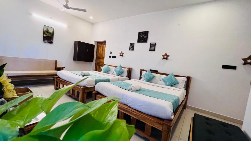 a room with two beds with blue pillows at THE LUXE HOTEL in Puducherry