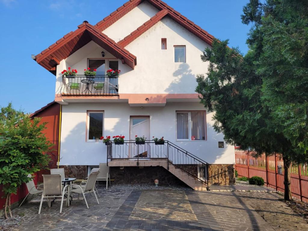 une maison avec un balcon, une table et des chaises dans l'établissement Vila Castelana, à Căciulata