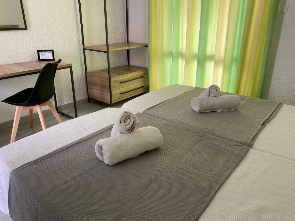 a bedroom with two beds with towels on them at Georgina in Agia Marina Aegina
