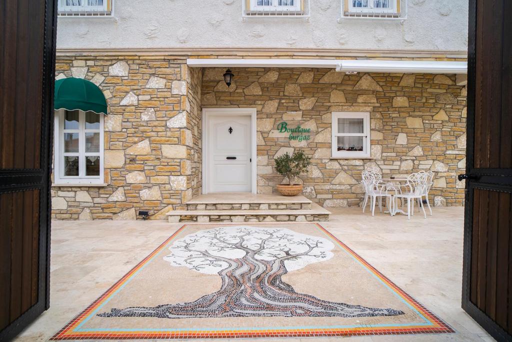 an entrance to a stone building with a tree rug at B&Y Burgaz in Selcuk