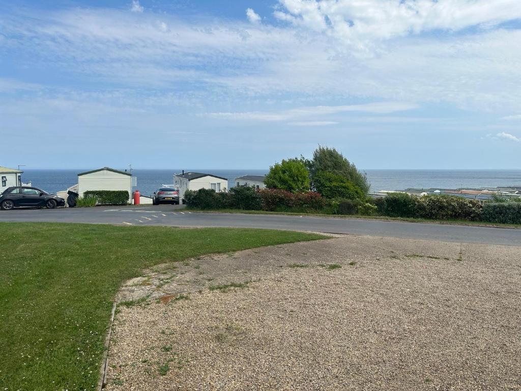 a road next to the ocean with cars parked on it at Ocean View B3 in Hartlepool