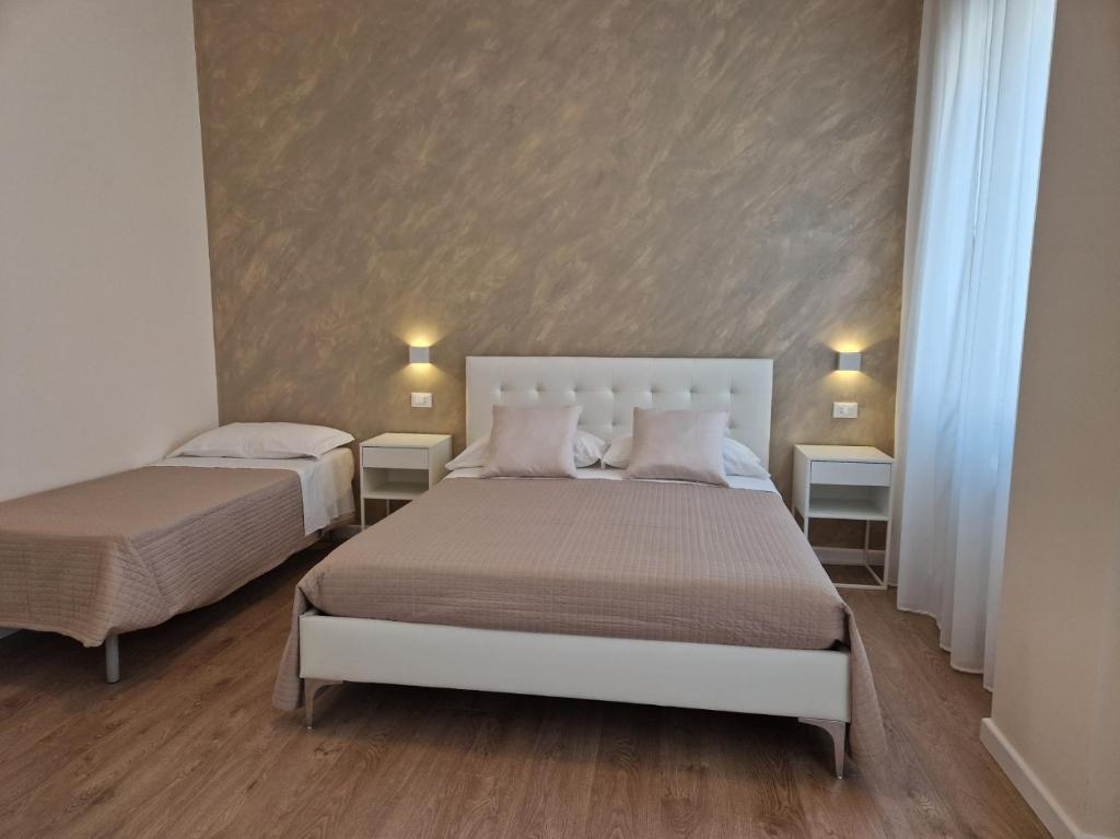 a bedroom with two beds and two side tables at City Center Suite in Termoli