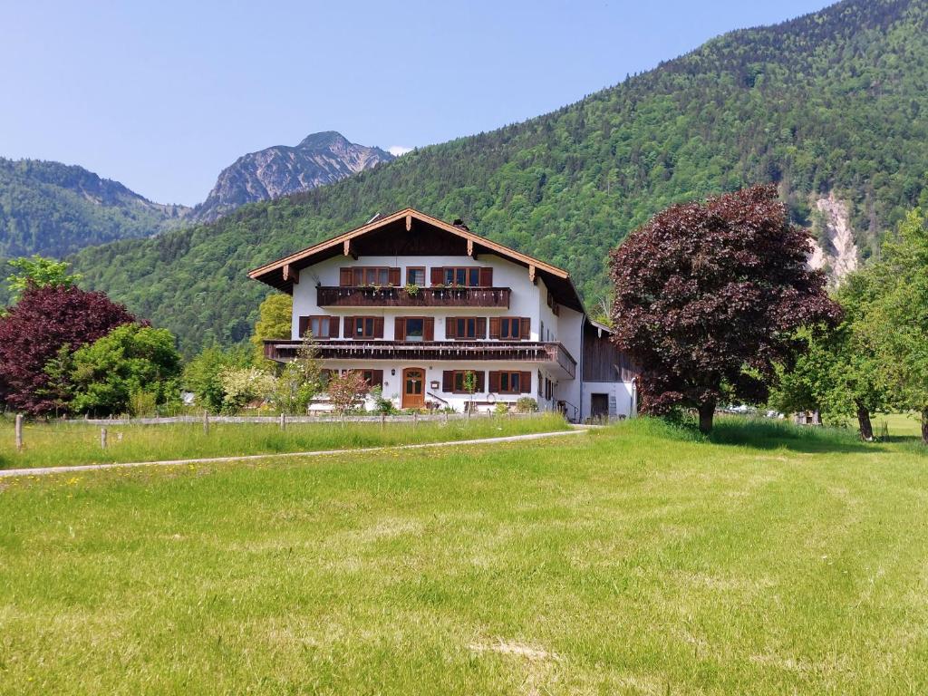 a large house in a field with mountains in the background at Pilzhof in Schleching
