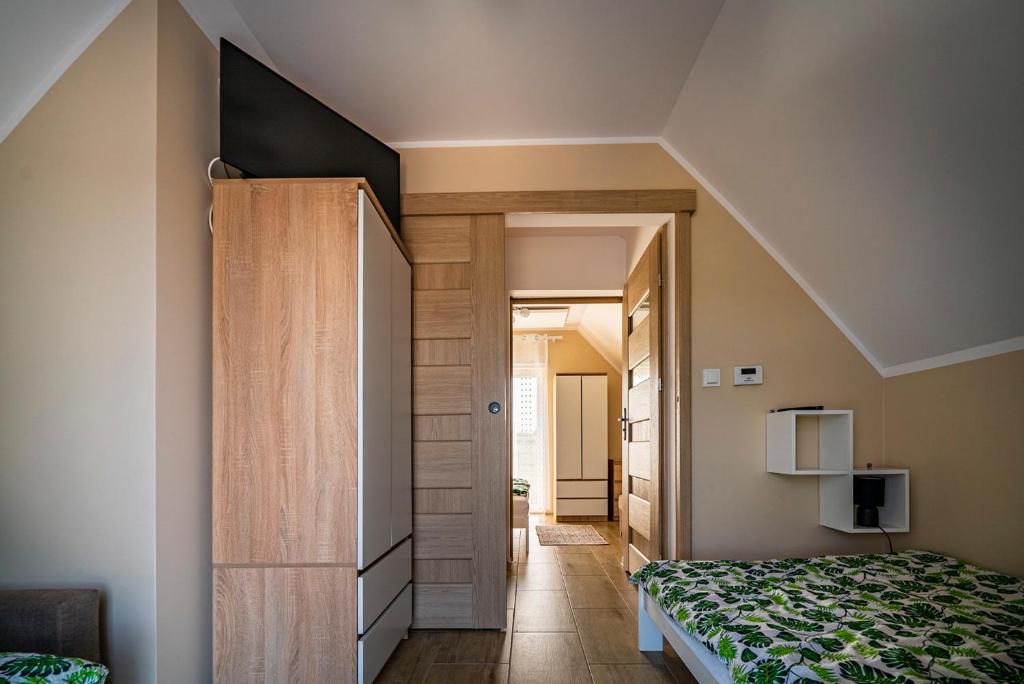Schlafzimmer mit einem Bett und einer Holztür in der Unterkunft Szmaragdowe Morze in Władysławowo