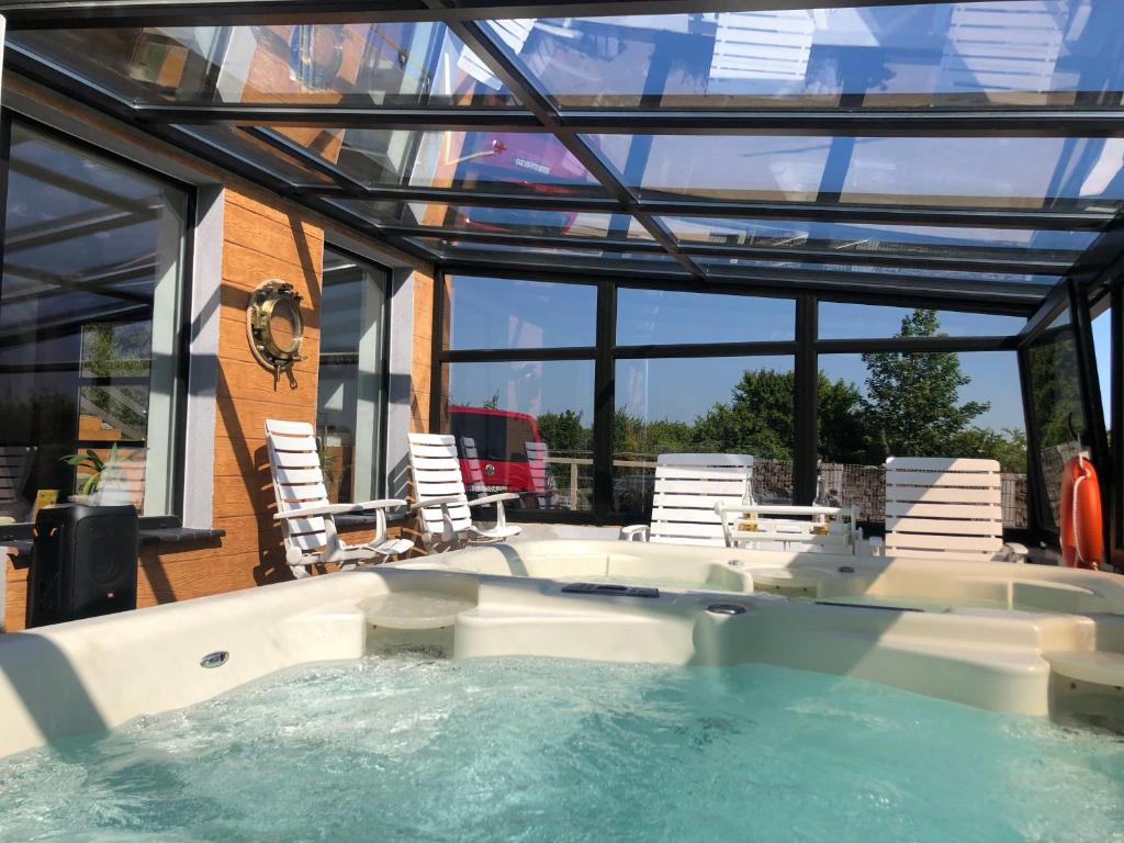 a hot tub in a house with chairs and windows at Willa i Domki Primore in Władysławowo