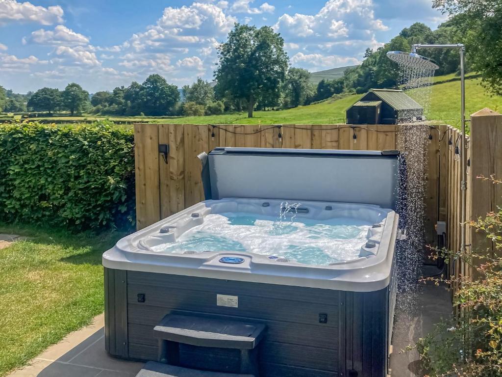 a hot tub in a backyard with a fence at Carr View Farm in Bamford