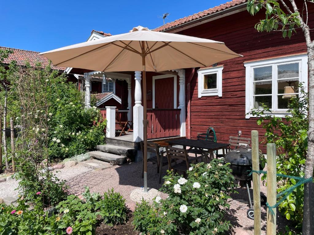 ein Haus mit einem Tisch und einem Sonnenschirm in der Unterkunft Villa Wargquist in Djuras