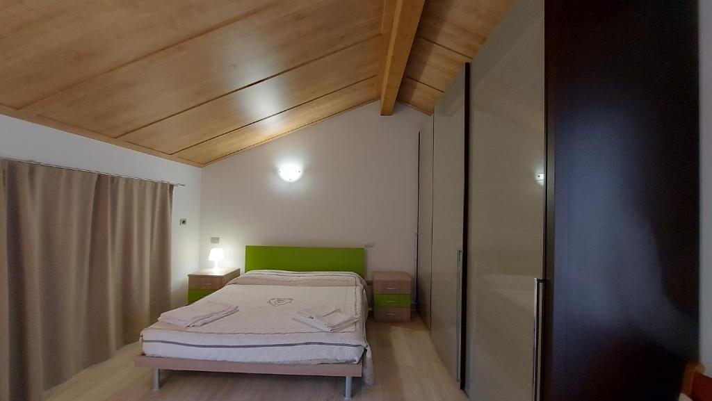 een kleine slaapkamer met een bed en een houten plafond bij B&B Santa Croce in Fanano