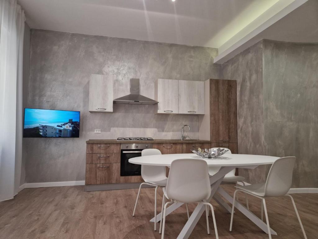a kitchen with a white table and chairs at City Center Apartment in Termoli