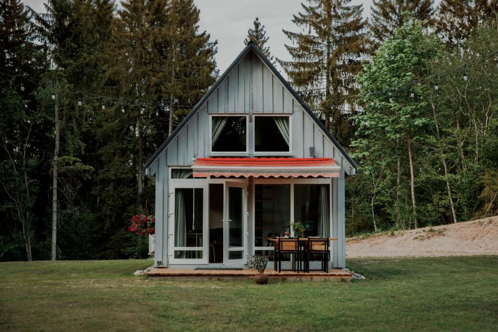 a tiny house with a porch on a field at Wolf Cottage 