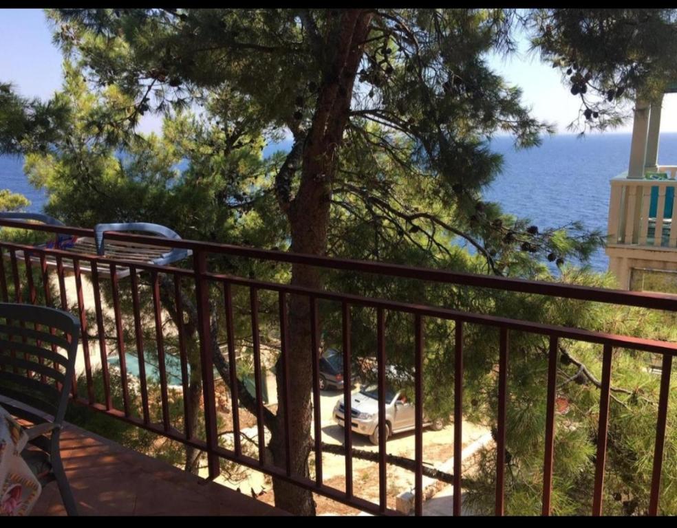 a balcony with a view of the water and a tree at Apartmani Kerum in Jelsa