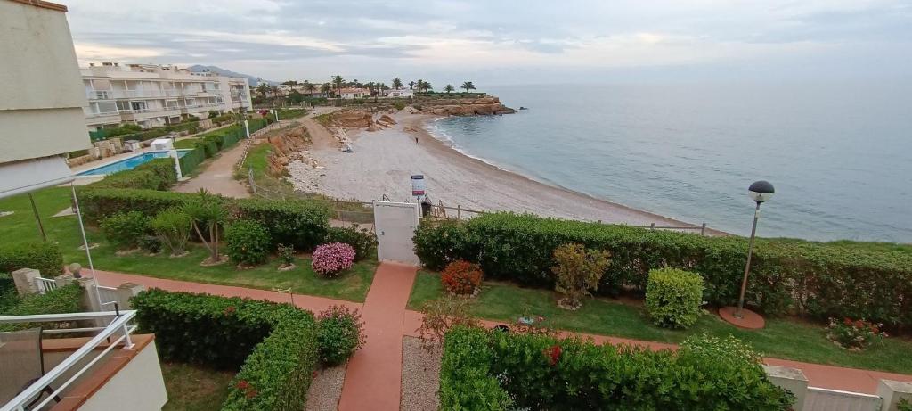 a view of a beach and the ocean from a balcony at Apartamento Cala Montero I in Vinaròs
