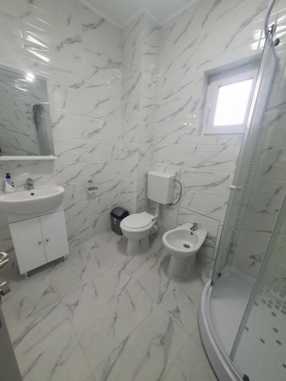 uma casa de banho branca com um WC e um lavatório em CAZARE EDI em Corbu