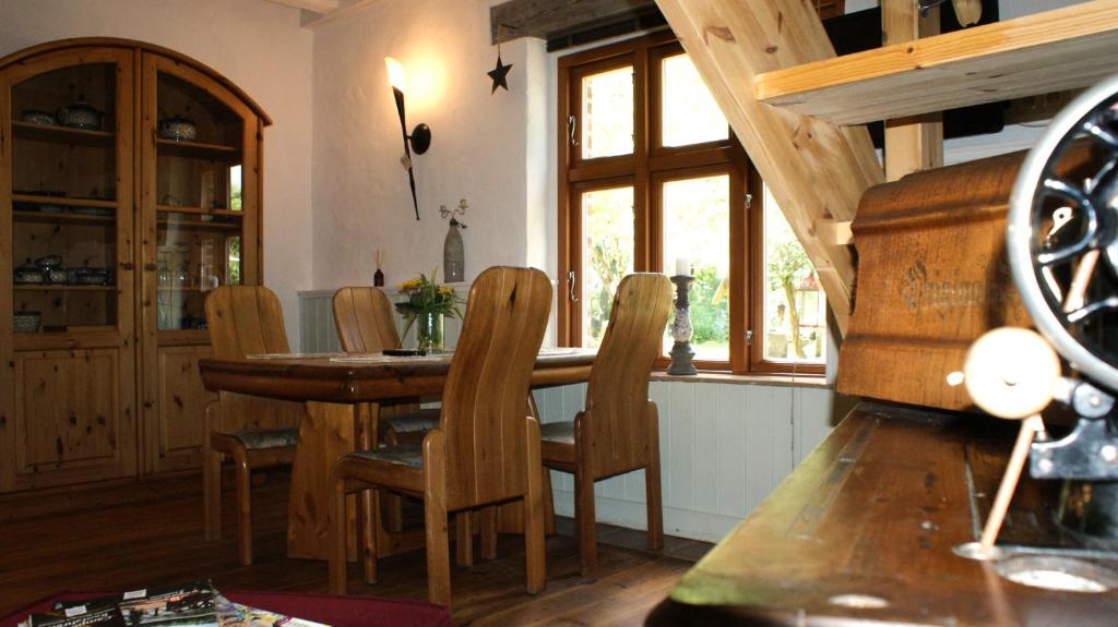 een eetkamer met een houten tafel en stoelen bij Ferienwohnung Fuchsberge in Letschin