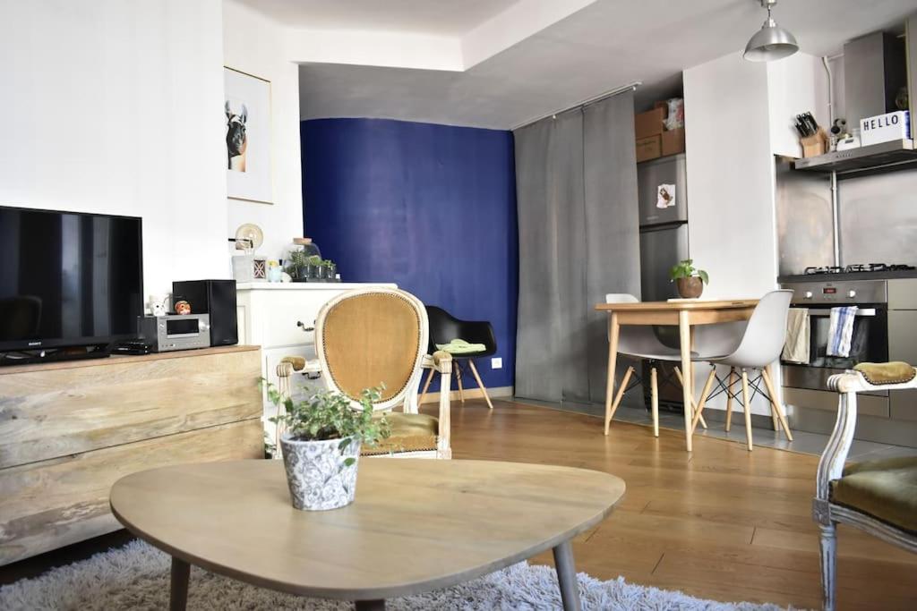 un salon avec une table et une télévision dans l'établissement Appartement cosy plein cœur de Marseille, à Marseille