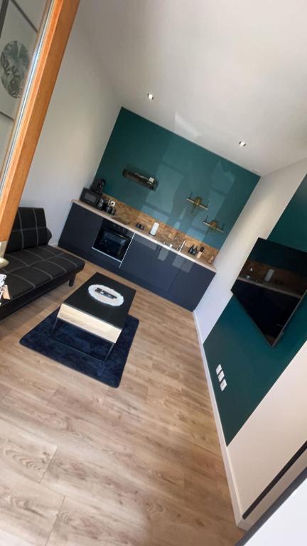 的住宿－L'EMERAUDE，客厅拥有绿色的墙壁和木地板。