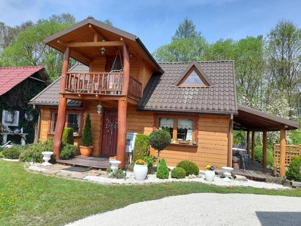 Cette maison en bois dispose d'un balcon et d'une terrasse couverte. dans l'établissement Chata Magnata, à Zamość