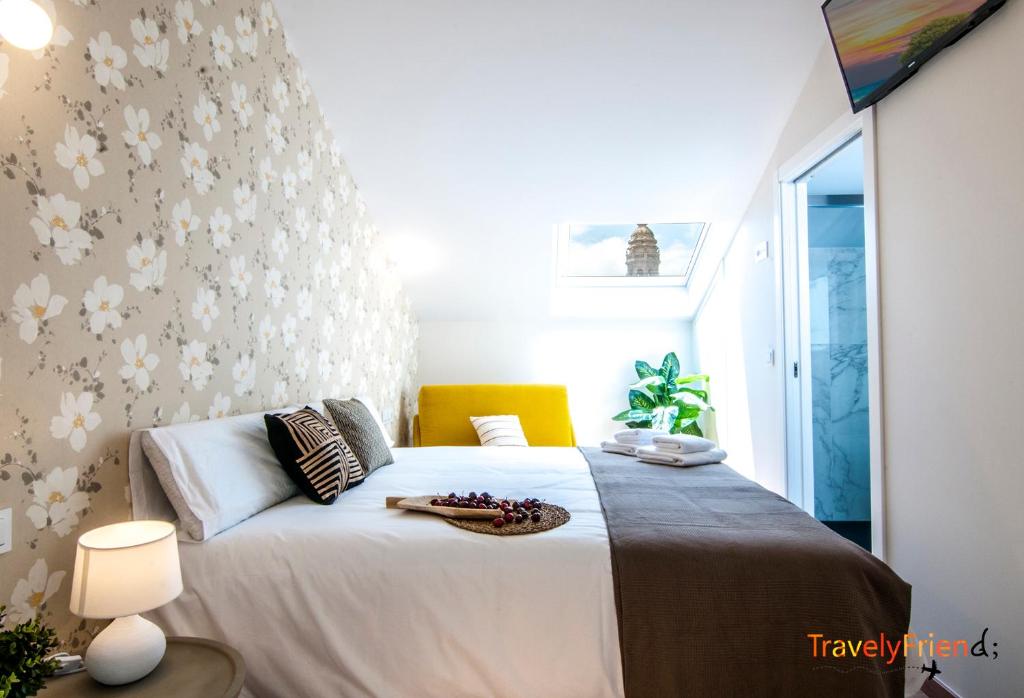 sypialnia z dużym łóżkiem ze wzorzystą kwiatową ścianą w obiekcie Apartment with views of the Cathedral w Santiago de Compostela