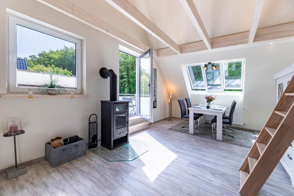 ein Wohnzimmer mit einem Kamin und einem Tisch in der Unterkunft Haus Hamburg Wohnung 2 in Hohwacht