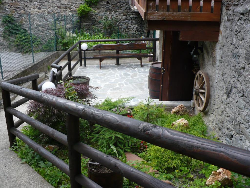 a wooden fence with a bench in a garden at Casa Vacanze Corteno Golgi Aprica in Alpe Strencia