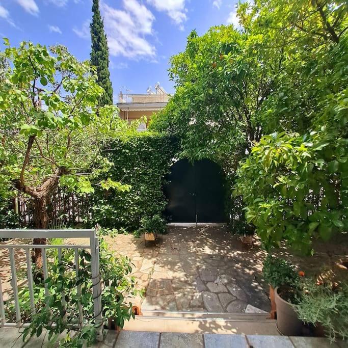 a courtyard with a garage with trees and bushes at 20' from the airport,20' from the center of Athens in Athens