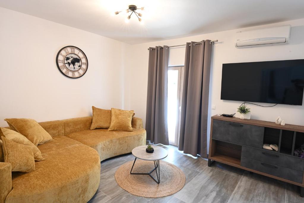 a living room with a couch and a flat screen tv at Apartment Mina Dream in Jelsa