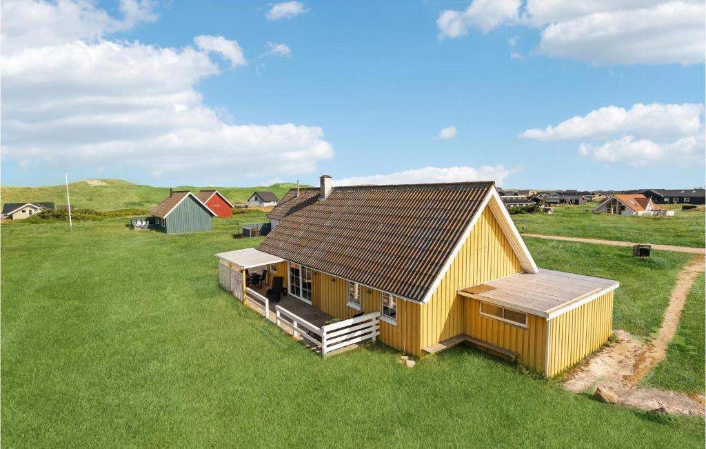une petite maison jaune dans un champ d'herbe dans l'établissement Amazing Home In Harbore With 2 Bedrooms, Sauna And Wifi, à Harboør