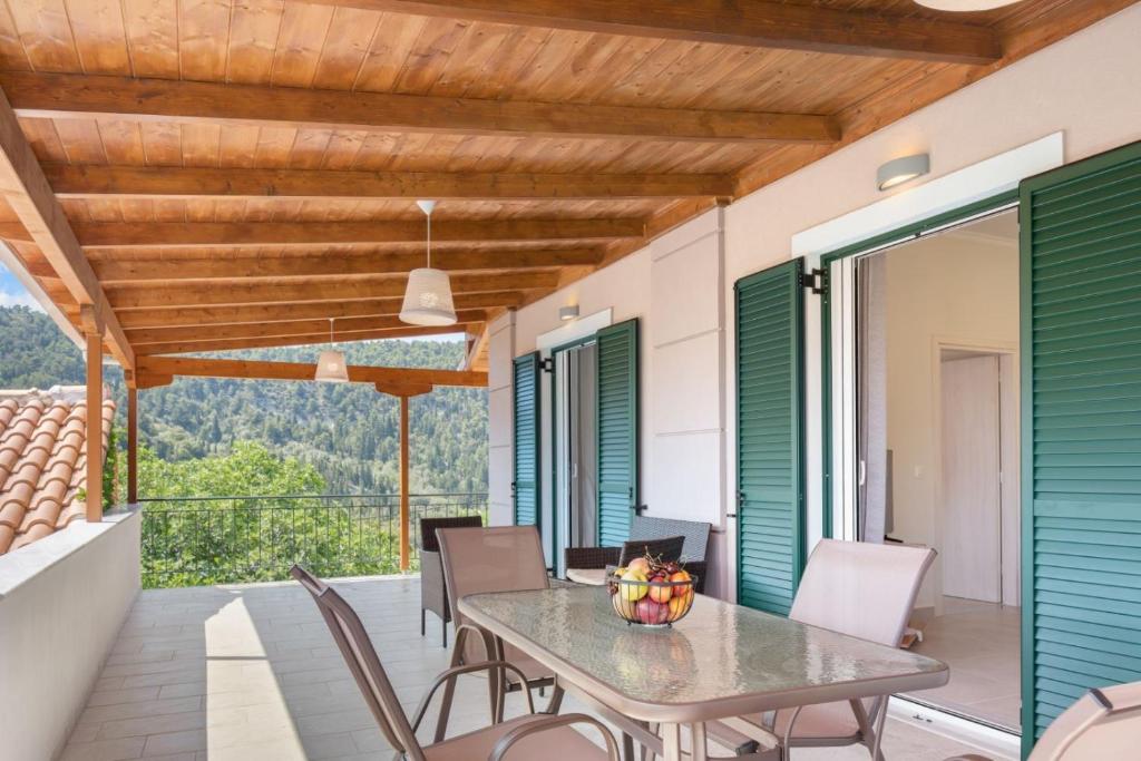 uma sala de jantar exterior com mesa e cadeiras em Ameli Apartment , Spacious With Mountain View, Lefkada em Dhráganon