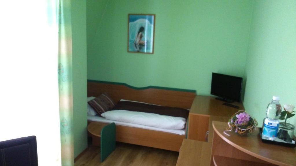 a bedroom with a bed and a desk with a computer at Penzión Rekrea in Levice