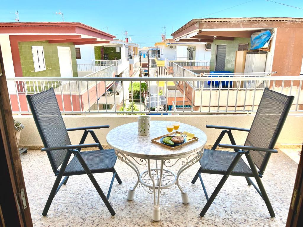 eine Terrasse mit einem Tisch und Stühlen auf dem Balkon in der Unterkunft Apartamento OLIVA PLAYA - PAU PI in Oliva