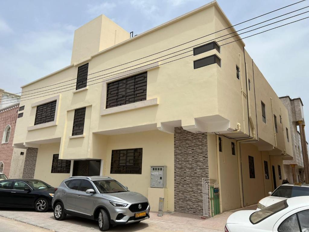 un bâtiment avec des voitures garées devant lui dans l'établissement Red-3 - New Salalah, à Salalah