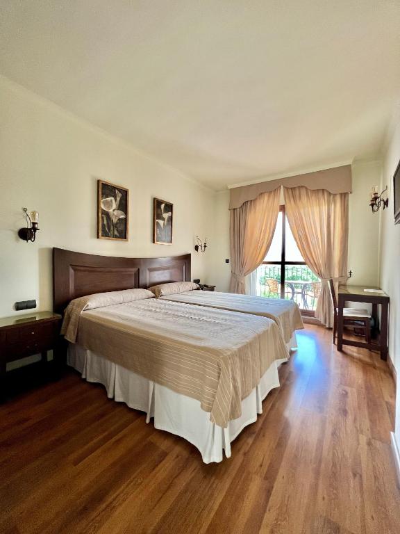 a bedroom with a large bed and a window at Los Dólmenes in Antequera