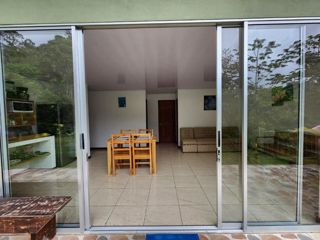 une porte coulissante en verre d'une terrasse avec une table. dans l'établissement Selvática del Toro, à Bajos del Toro