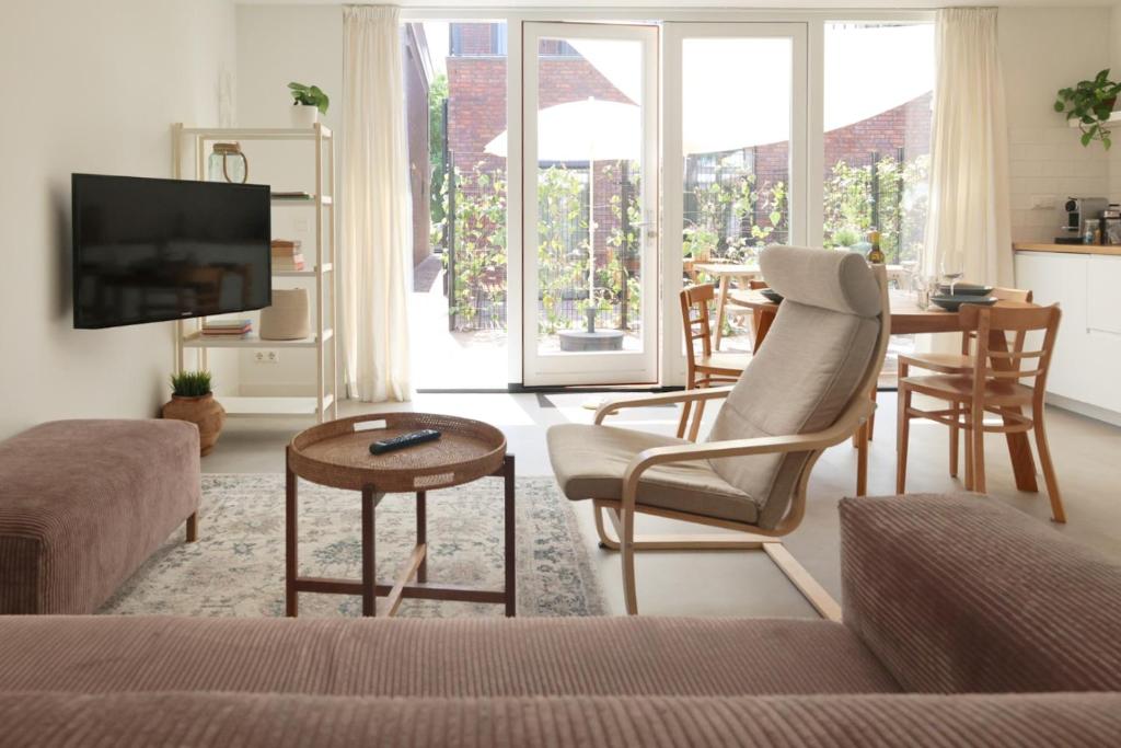 ein Wohnzimmer mit einem Sofa und einem Tisch in der Unterkunft Zilt aan Zee in Egmond aan Zee
