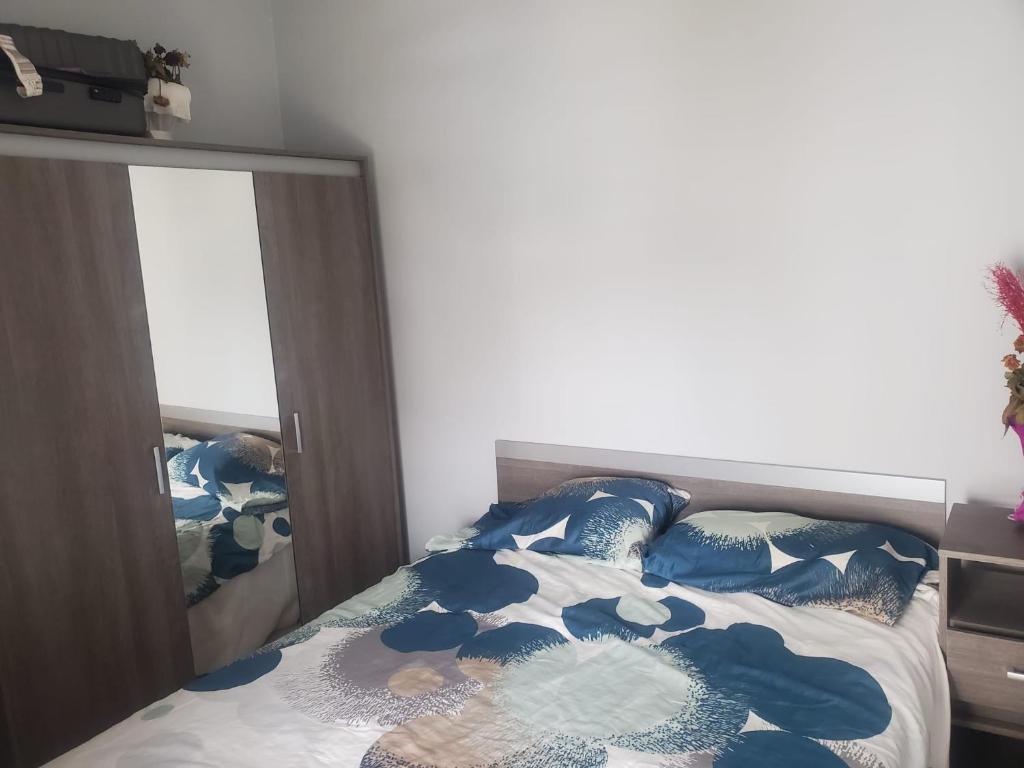 Schlafzimmer mit einem Bett mit einer blauen und weißen Bettdecke in der Unterkunft Joli appartement in Agadir
