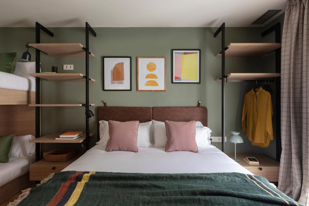 a bedroom with a large bed with pink pillows at TOC Hotel Las Ramblas in Barcelona