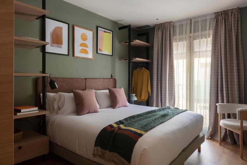 a bedroom with a large bed with pink pillows at TOC Hotel Las Ramblas in Barcelona