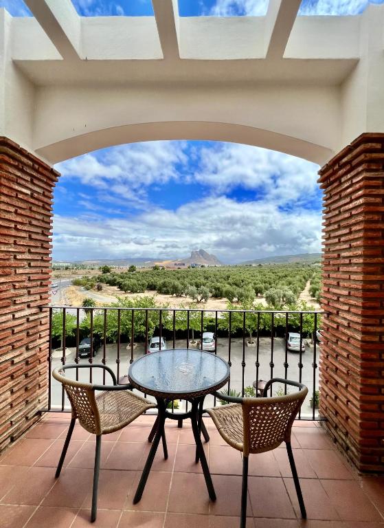 a patio with a table and chairs on a balcony at Los Dólmenes in Antequera