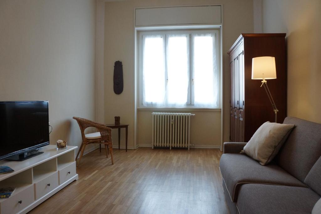 ein Wohnzimmer mit einem Sofa und einem TV in der Unterkunft Apartment Papiniano 38 in Mailand