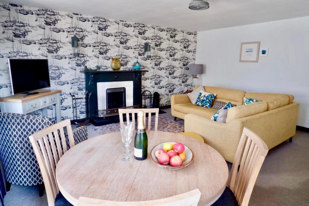 a living room with a table with a bowl of fruit on it at Saffron House in Fowey